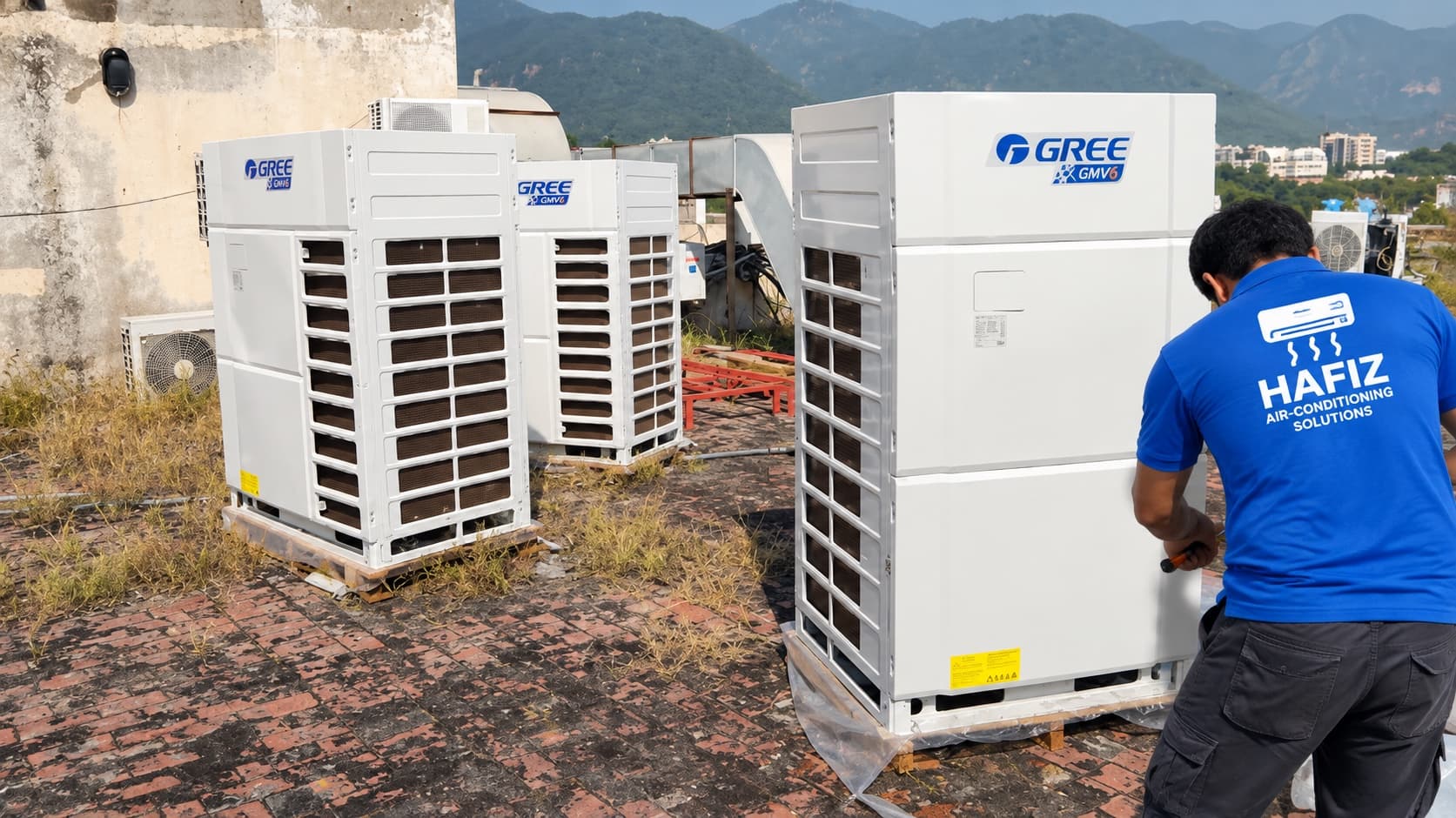 Technician working on Gree VRF outdoor units on the rooftop at Evacuee Trust Complex