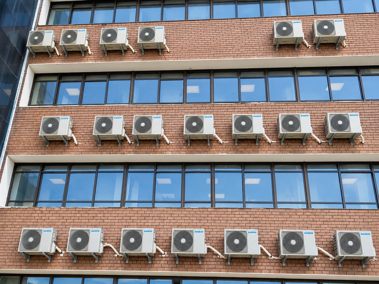 Split outdoor units in rows across the brick facade at Kohat Institute of Medical Sciences