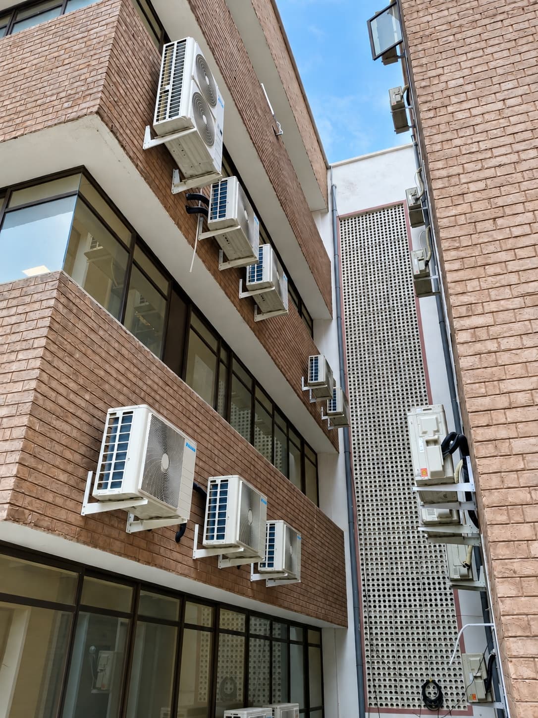 Outdoor units stacked up a narrow facade at Kohat Institute of Medical Sciences