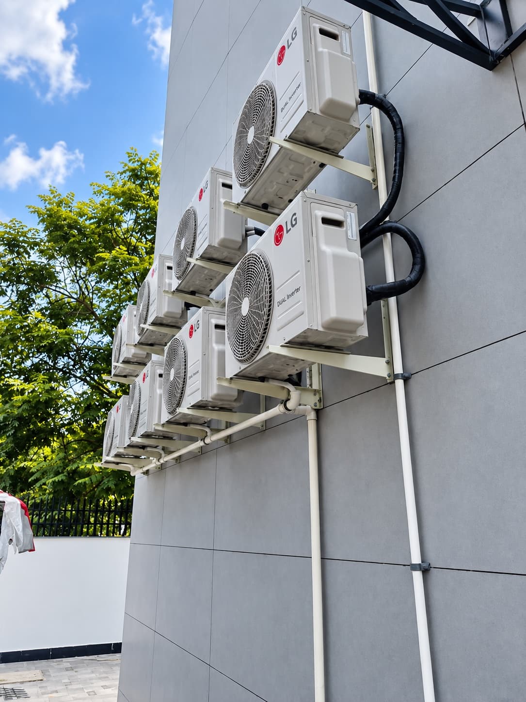 LG outdoor units mounted one above another on a residential wall